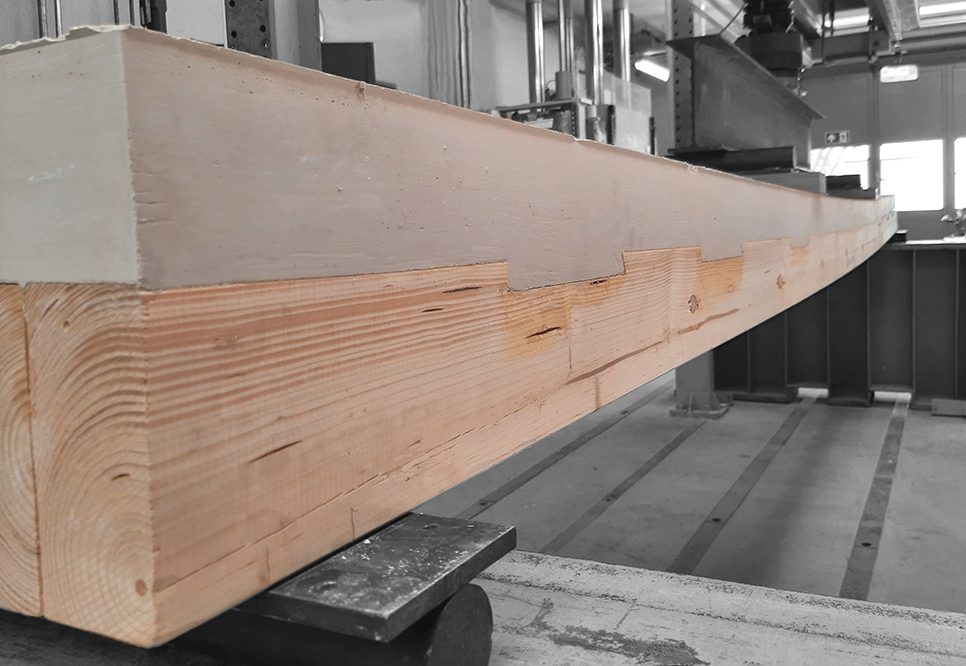 Holz-Beton-Verbunddecken (HBV-Decken) unter Verwendung ökologischer Betone und Textilbewehrung stellen hinsichtlich Leistungsfähigkeit und schneller Bauzeit eine effiziente Alternative zu konventionellen Stahlbetondecken dar. Dadurch, dass ungefähr die unteren 2/3 des Stahlbetonquerschnitts (Zugzone) durch Holz als Stahl- und Biegesteifigkeitsausgleich ersetzt werden, sind zudem große CO2-Einsparungen möglich. (© Michael Mikoschek, Hochschule Augsburg)