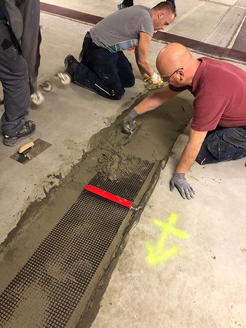 Reinstandsetzung am Beispiel einer Tiefgarage: Sogenannter KKS-Carbonbeton wurde auf Basis eines carbontextilbewehrten Spezialmörtels sowie eines kathodischen Korrosionsschutzes (KKS) entwickelt. Das Bild zeigt den Einbau des KKS-Carbonbeton im Laminierverfahren – roter Bereich: Primäranodeneinspeisung. (© Koch GmbH)