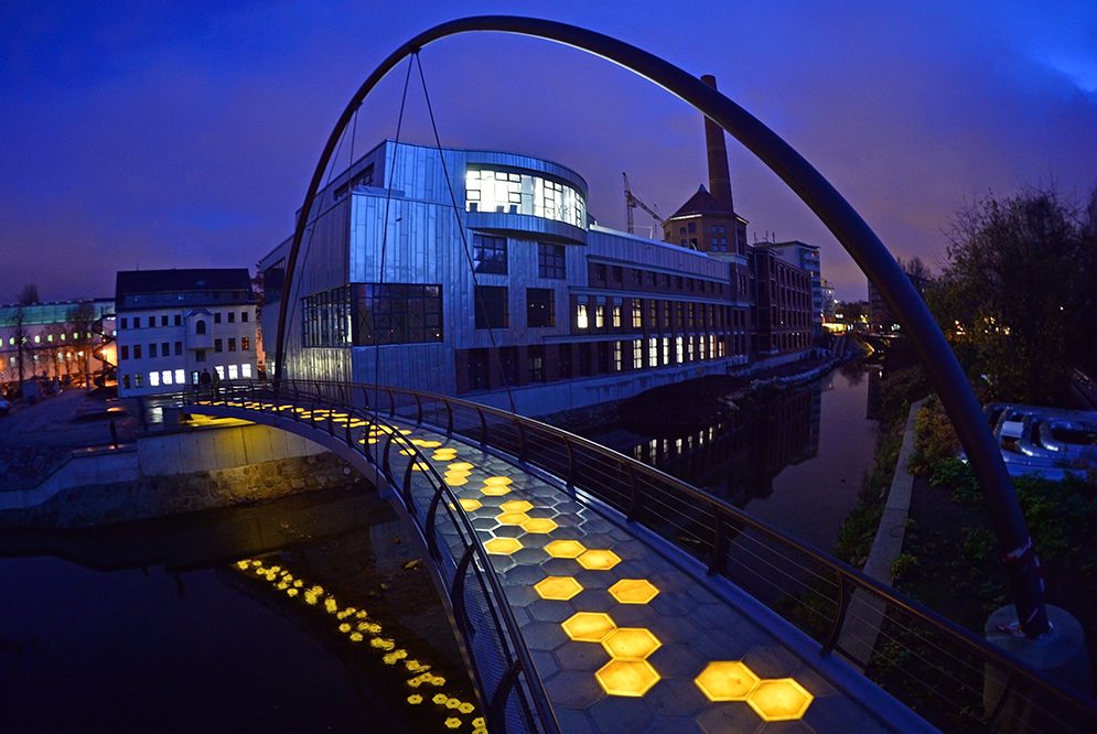 Gehbelag aus Glasfaser-Kunststoff-Verbund, realisiert mit ca. 2,60 m langen Modulen als Wabensandwich auf einer Brücke mit ca. 30 m Spannweite in Chemnitz. Die Integration einer interaktiven LED-Beleuchtung gestattet verschiedene Lichtszenarien. (© Andreas Ehrlich;  TU Chemnitz, LBW)