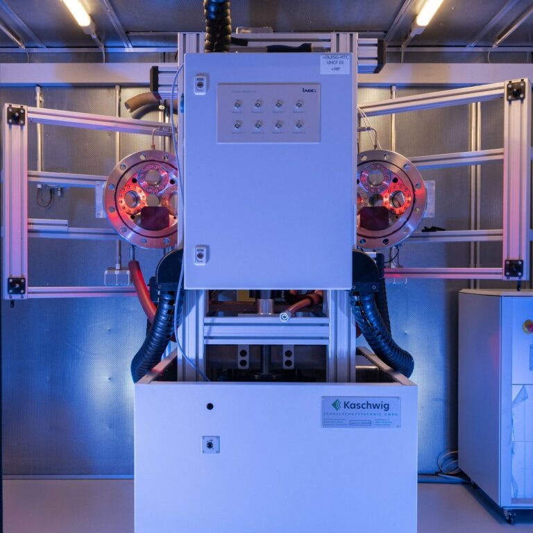 Der MTC-VHCF-Prüfstand (Very High Cycle Fatigue) eignet sich auf Grund der hohen Testfrequenz von 1.000 Hertz besonders für Lebensdauertests mit einer sehr hohen Zahl an Lastwechseln. Im Bild sind vier kreisförmige optische Zugänge zum Druckbehälter zu erkennen. Die unterschiedlichen Färbungen der Fenster deuten deren unterschiedlichen Oberflächenbeschichtungen an – angepasst auf die im nächsten Schritt zu installierende optische Messtechnik sowie des Laserheizsystems. Credit: DLR (CC BY-NC-ND 3.0)
